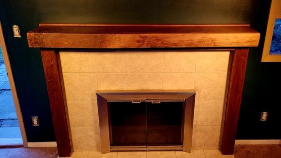 Custom hardwood fireplace mantel and surround framing a tiled firebox