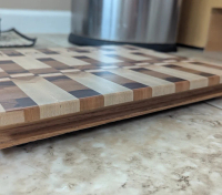 Custom engraved end-grain cutting board with intricate wood detailing.