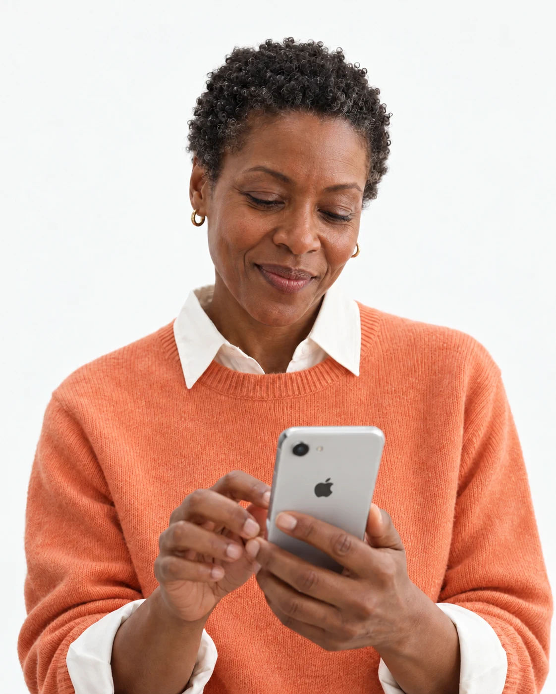 A woman in an orange sweater checking her phone