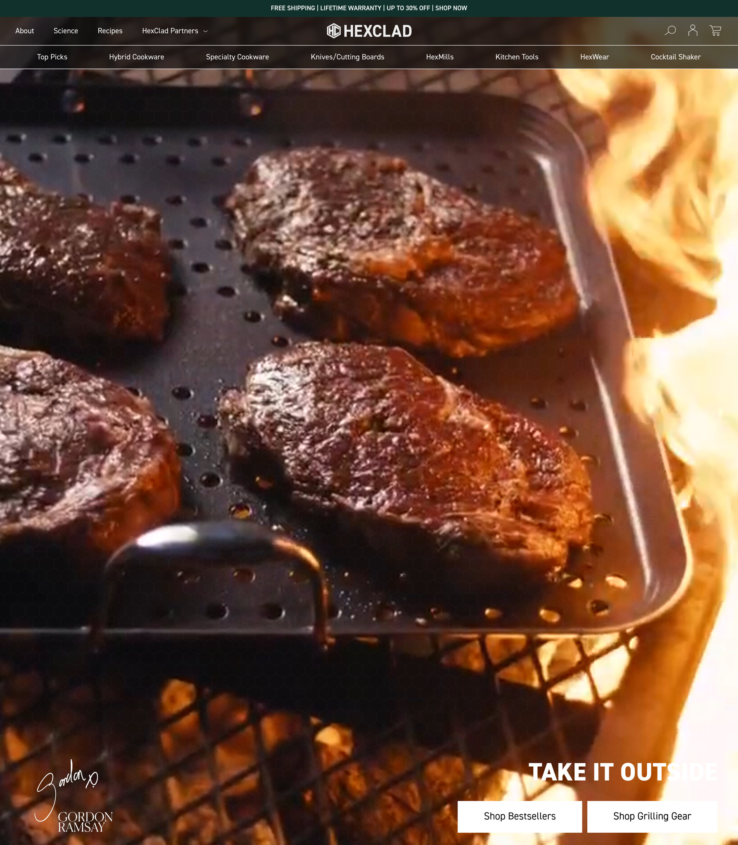 HexClad homepage: steaks searing over open flame, Gordon Ramsay's signature on the hero, and a free shipping / lifetime warranty / up to 30% off bar