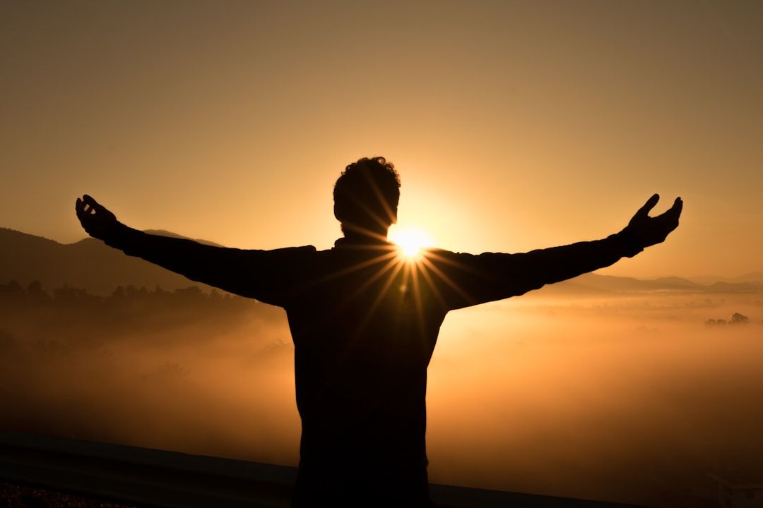 A person welcoming the sunrise with open arms