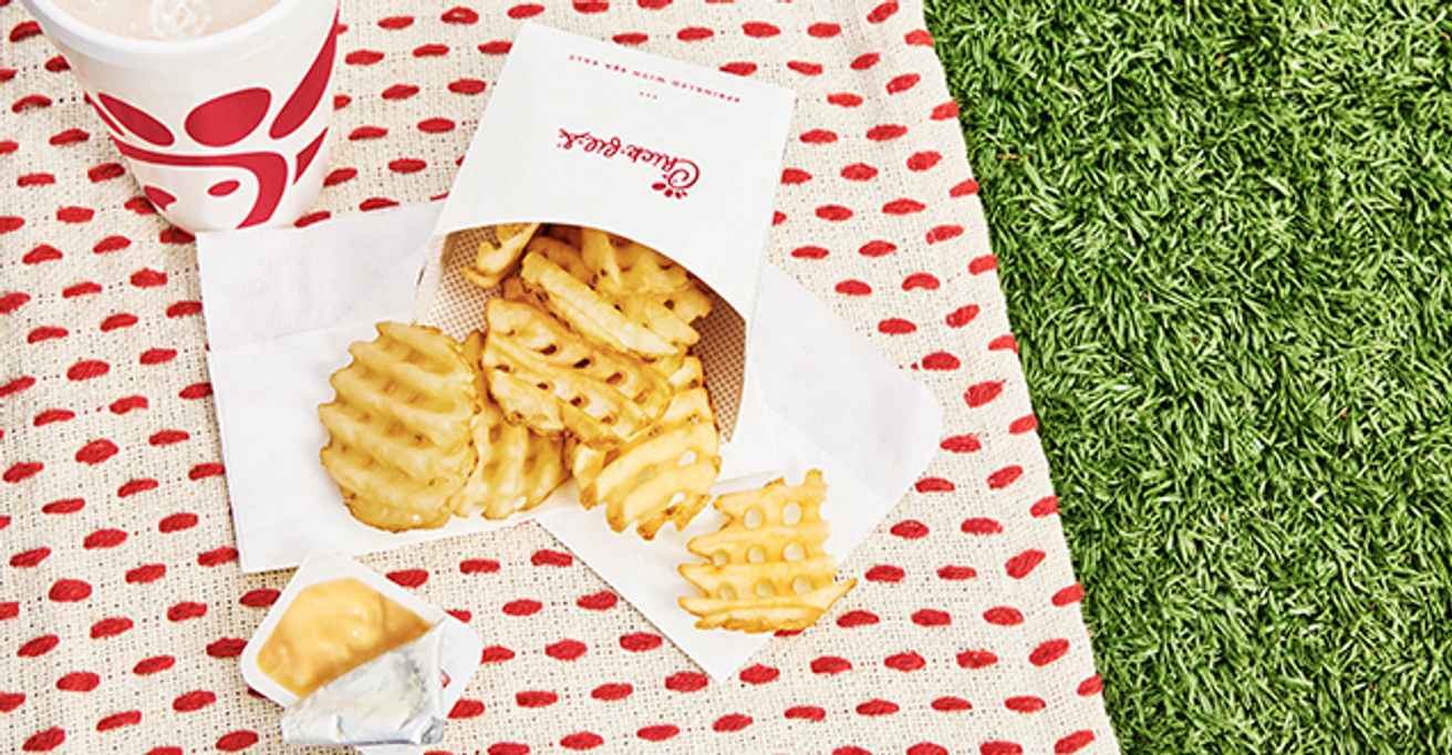 Waffle fries on napkins, on top of a picnic blanket