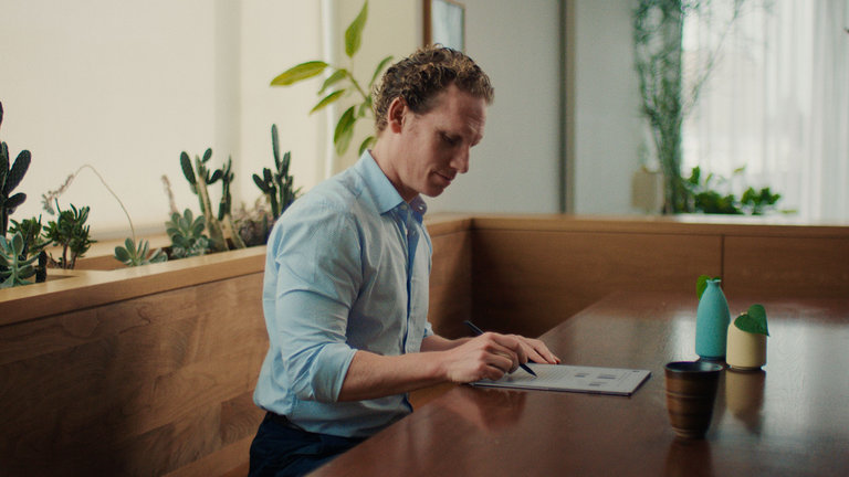A man reviewing a document at a table with the reMarkable paper tablet.