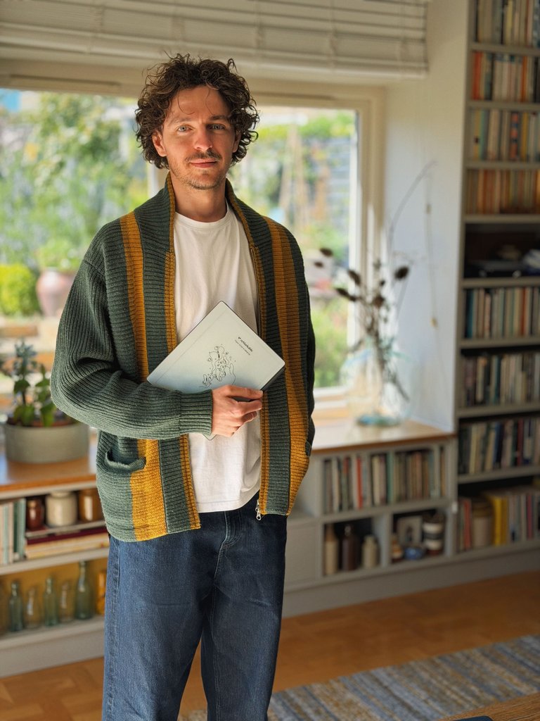 Jake Ogden standing while holding his reMarkable Paper Pure tablet.