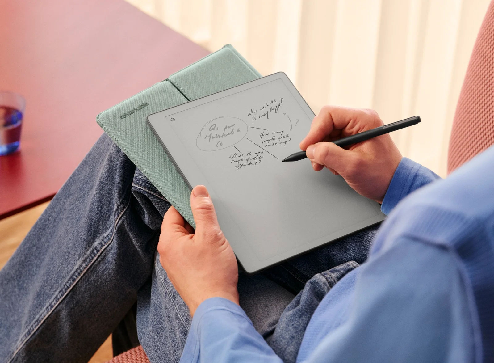 A woman holding a reMarkable Paper Pure in a Sleeve Folio