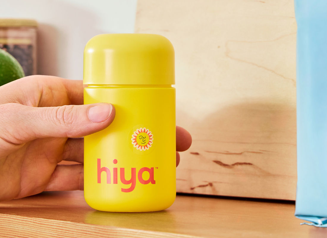 Hand holding a yellow Hiya kids multivitamin bottle