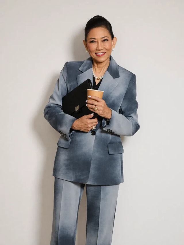 Chanida holding a portfolio and coffee cup