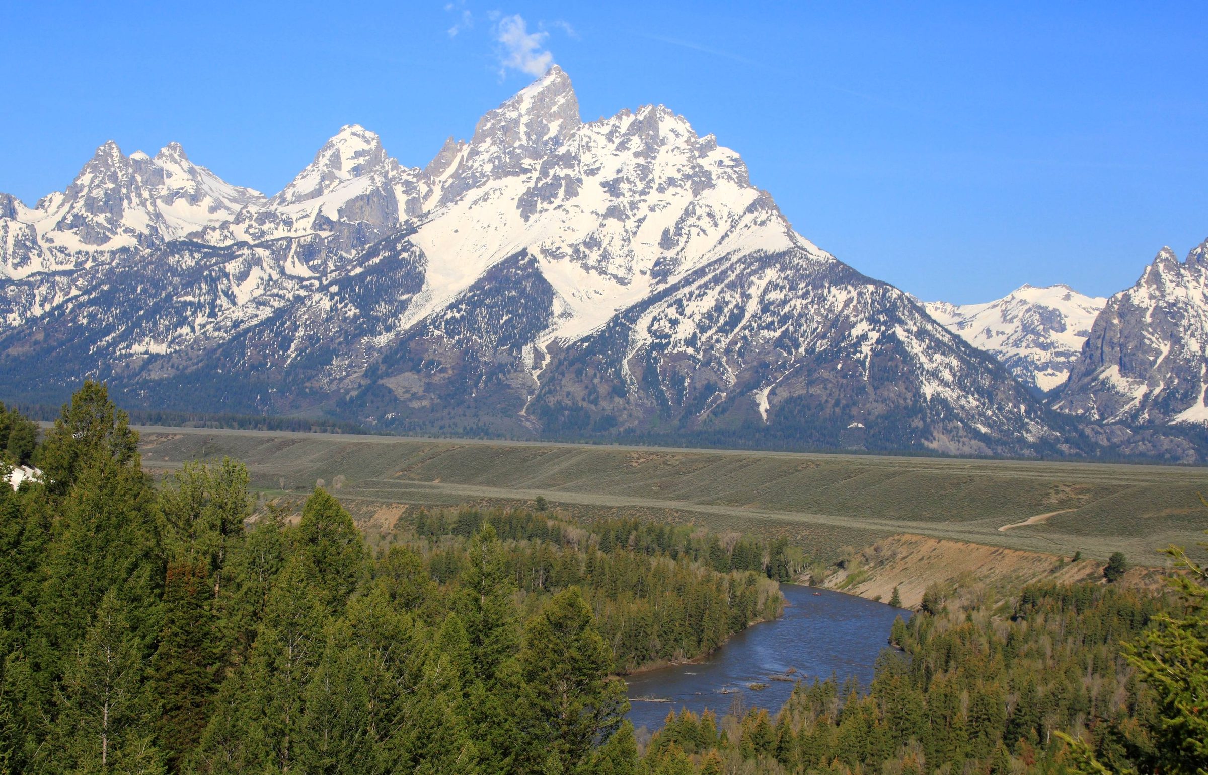 The snow-covered Teton Range rising above a bend of the Snake River, seen from Snake River Overlook
