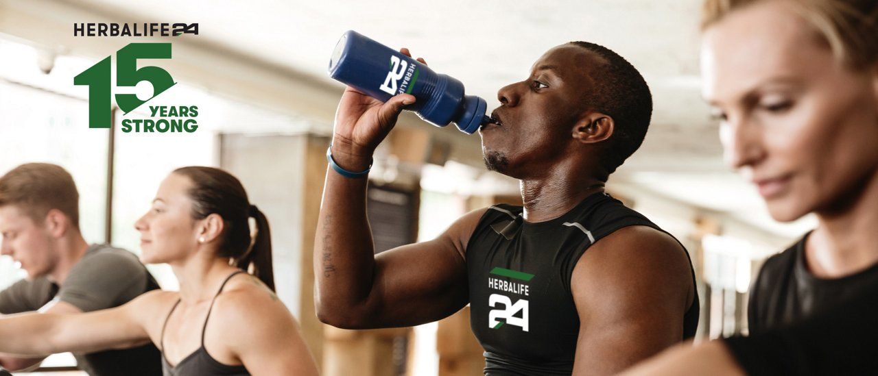 Athlete drinking from a Herbalife24 bottle in a gym