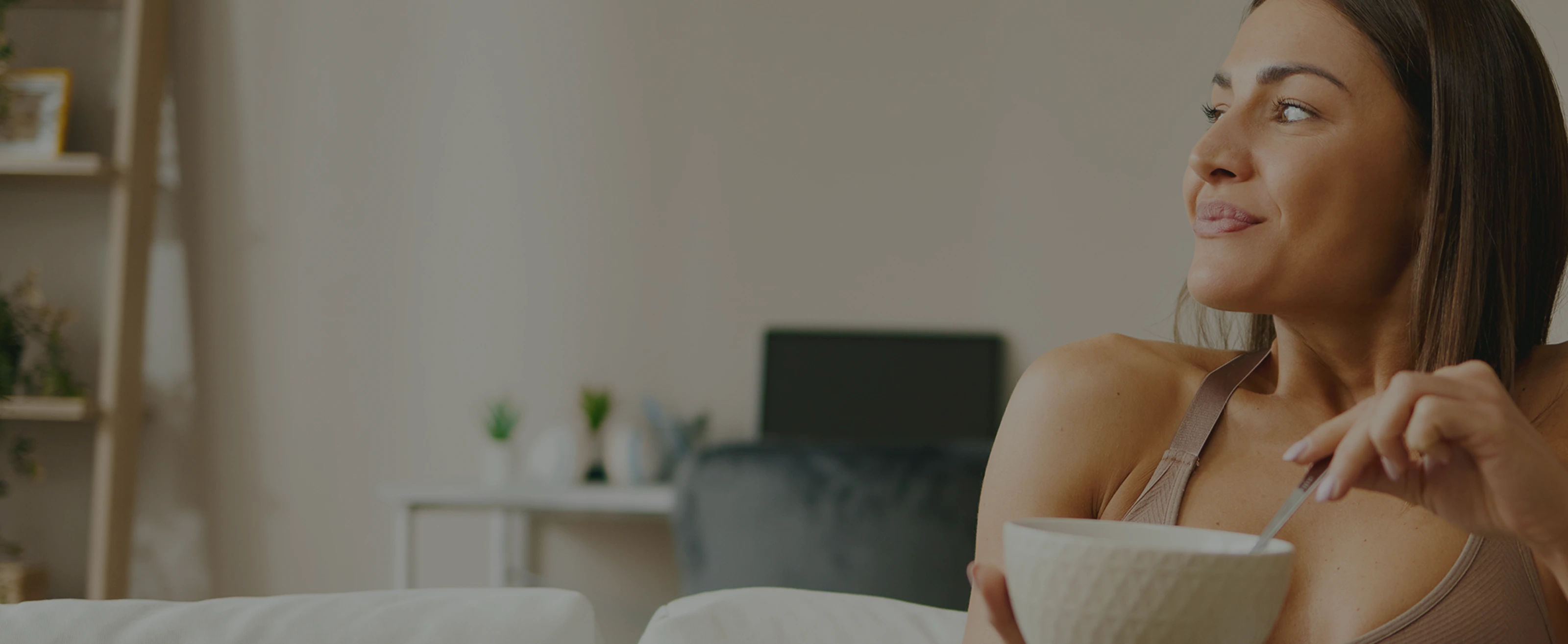 Woman smiling with cup in cozy home interior