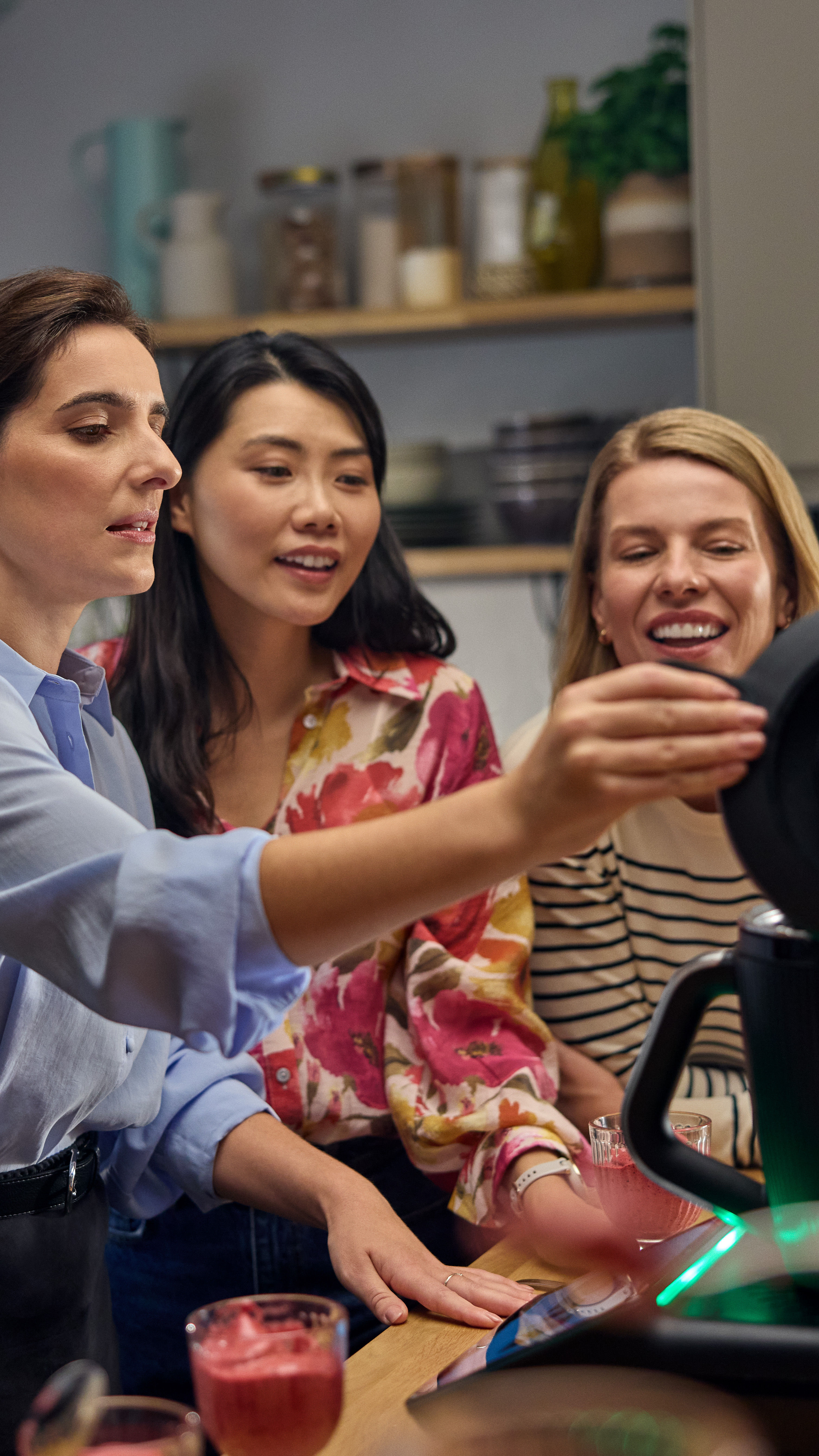 Three women using a Thermomix device