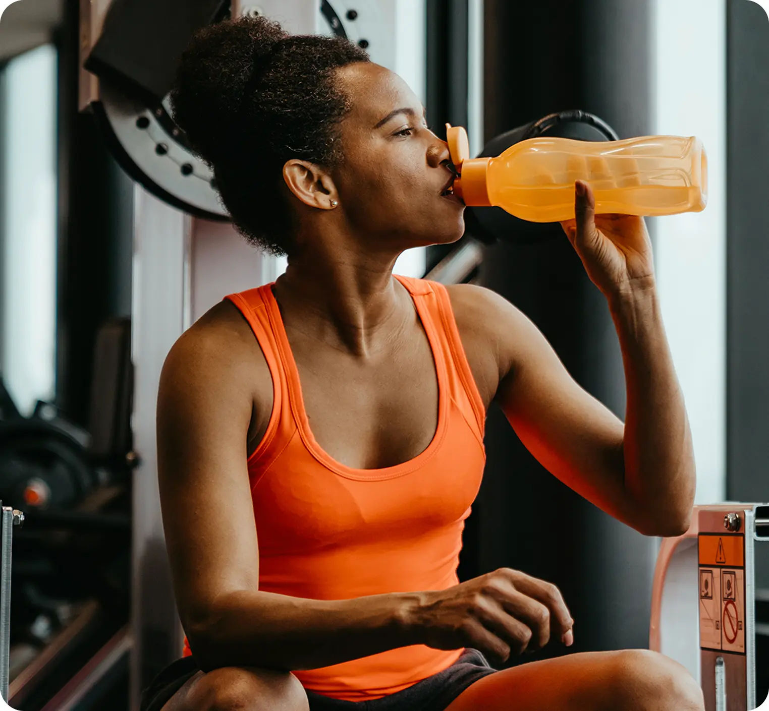 two women talking while holding various health and fitness items in a kitchen.