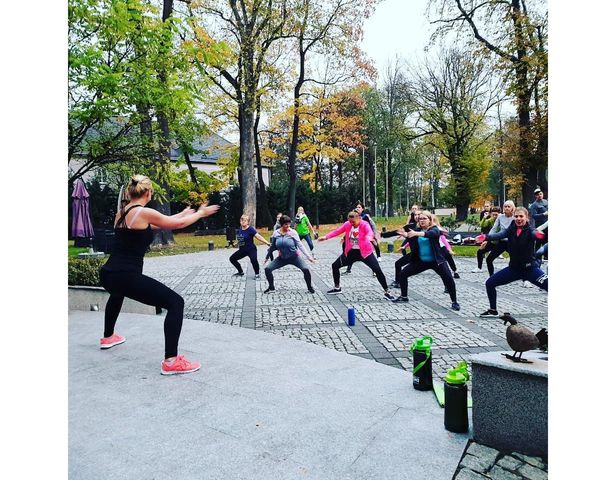Distributor leading a fitness workout of people outdoors