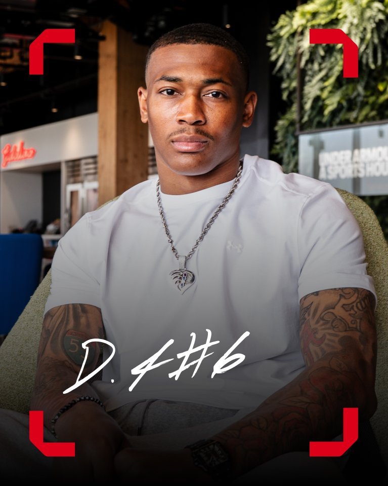 Athlete sits indoors wearing a white shirt with Under Armour logo and text d 4 6 overlaid.