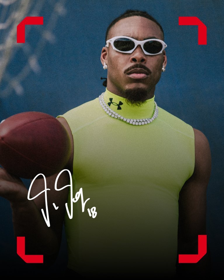 Athlete wears Under Armour neon sleeveless top and white sunglasses holding a football.