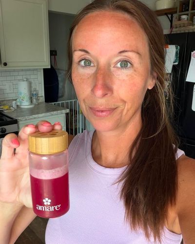 Amare community member holding an Amare drink bottle