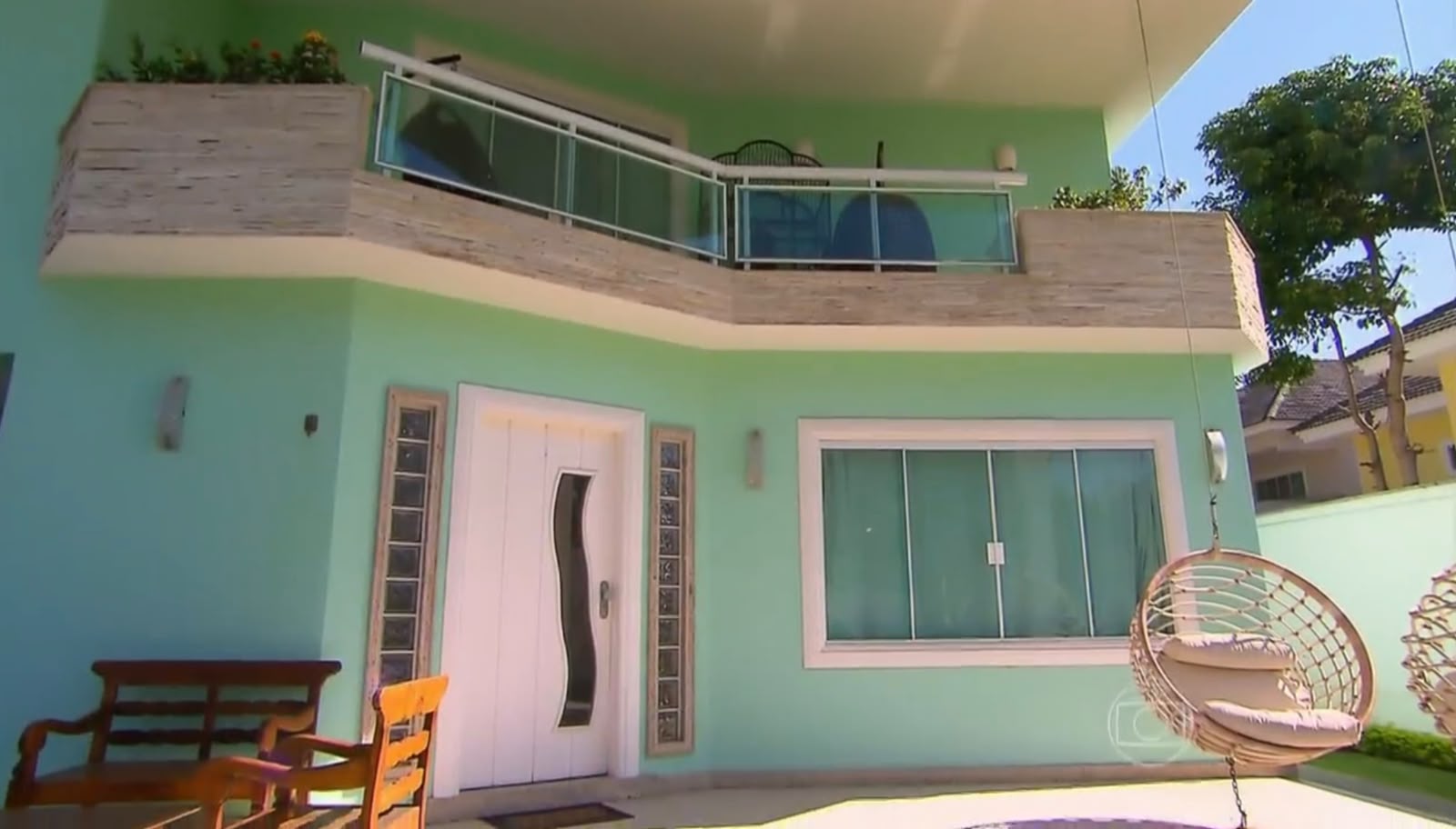 Latino conversa com Angélica na sala sofisticada de sua antiga residência, que tinha um piano e decoração em tons prateados.