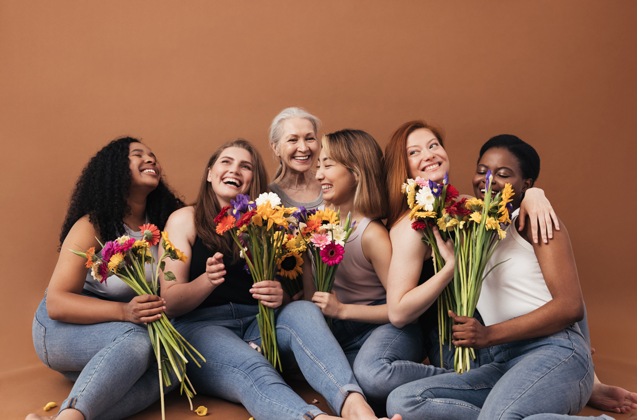 women holding flowers and laughing