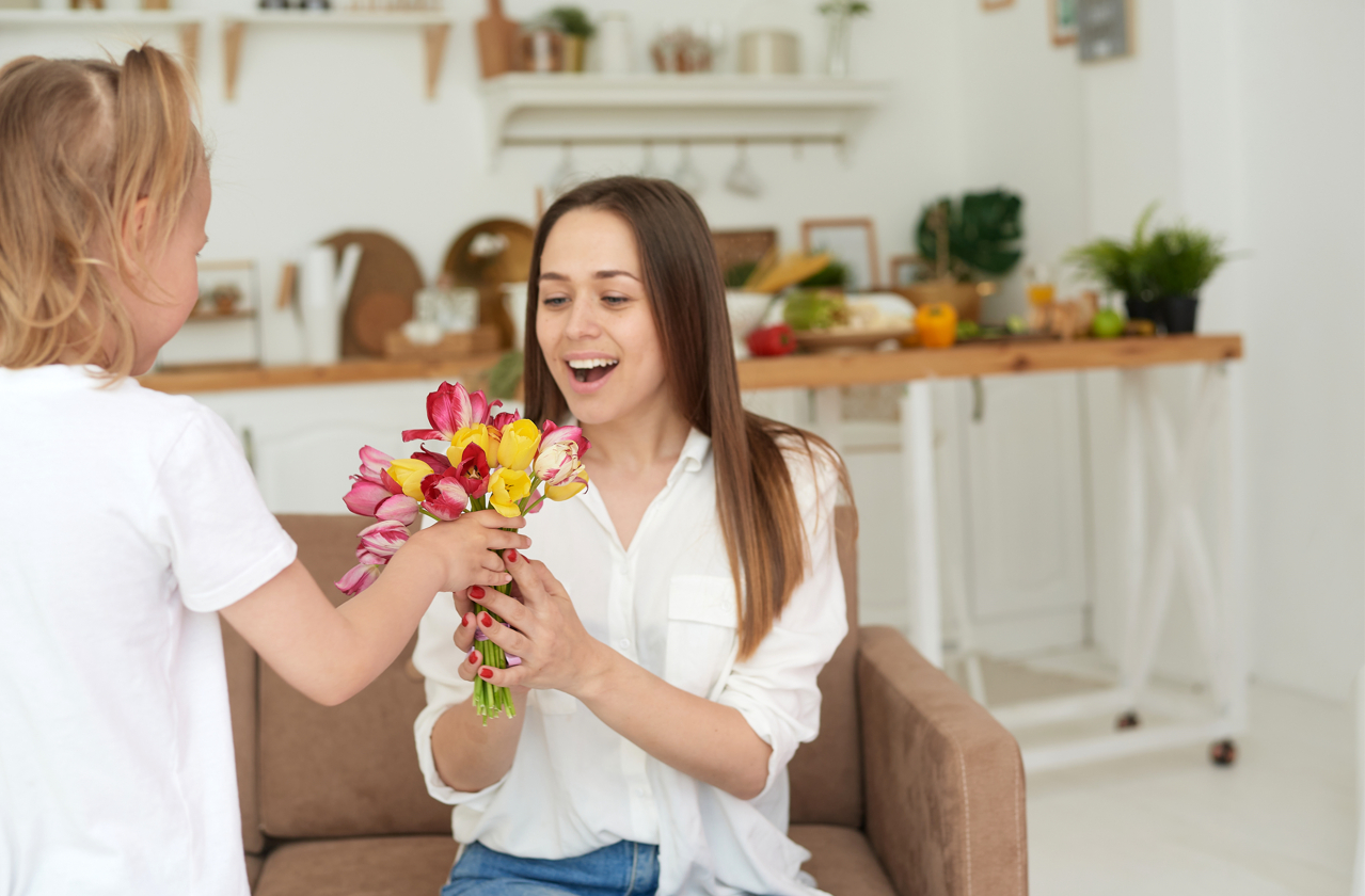 child giving flowers to mother