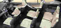 Interior shot of a vehicle featuring beige and black seats, dashboard controls, and a touchscreen display.