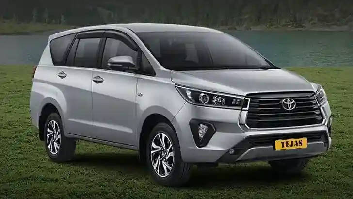 A silver Toyota SUV parked on grass near a lake, showcasing a clean, modern design and clear reflections.