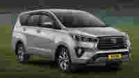 A silver Toyota SUV parked on grass near a lake, showcasing a clean, modern design and clear reflections.