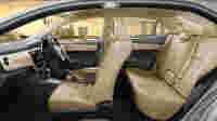 Spacious car interior with beige seats, featuring a modern dashboard and a city skyline visible through the windows.