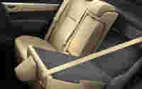 Beige leather backseat of a car with a folded-down center armrest and seatbelt visible.
