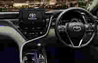Modern Toyota vehicle interior featuring a digital dashboard, touchscreen display, and steering wheel, set against a night backdrop.
