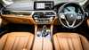 Luxurious car interior featuring leather seats, modern dashboard, touchscreen display, and gear shift in a BMW model.