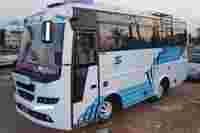 A white and blue bus parked on the roadside, displaying the name "Sri Maruthi" on the front.