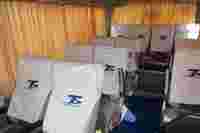 Interior of a travel bus with neatly covered seats and orange curtains, featuring a blue carpet aisle.