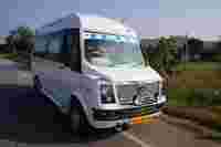 A white van with a grille design parked by the roadside, featuring the name "TEJAS" on the windshield and surrounded by greenery.