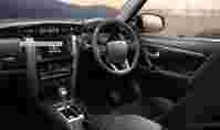 Interior of a Toyota Fortuner showcasing a steering wheel, dashboard controls, and a scenic background with mountains.