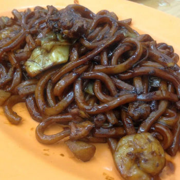 Fried Thick Yellow Hokkien Mee With Prawn, Pork Slices, Chinese Round Cabbage And Deep Fried Lard In Dark Soy Sauce