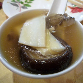 Double-boiled superior soup with whole chicken, mushroom, some shark fins, sea cucumber and sliced Abalone