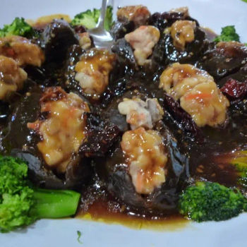 Black sea cucumber stuffed with pork/prawn/carrot and fish paste spread with an oyster like brown sauce and served on the side with blanched broccoli