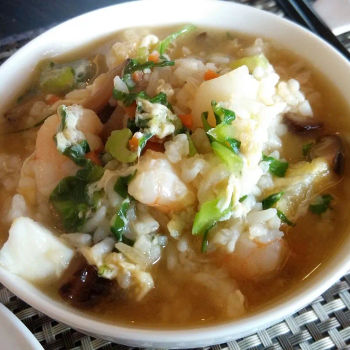 Stewed Rice With Assorted Seafood, Some Chopped  Vegetables Like Kai Lan In A Superior Liked Soup