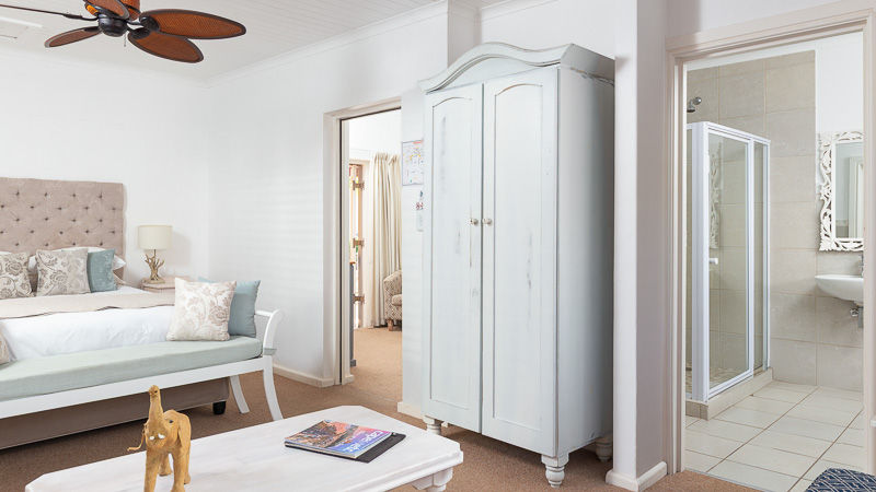 En suite bedroom at Russells in Port Owen, featuring warm tones and classic interior styling.