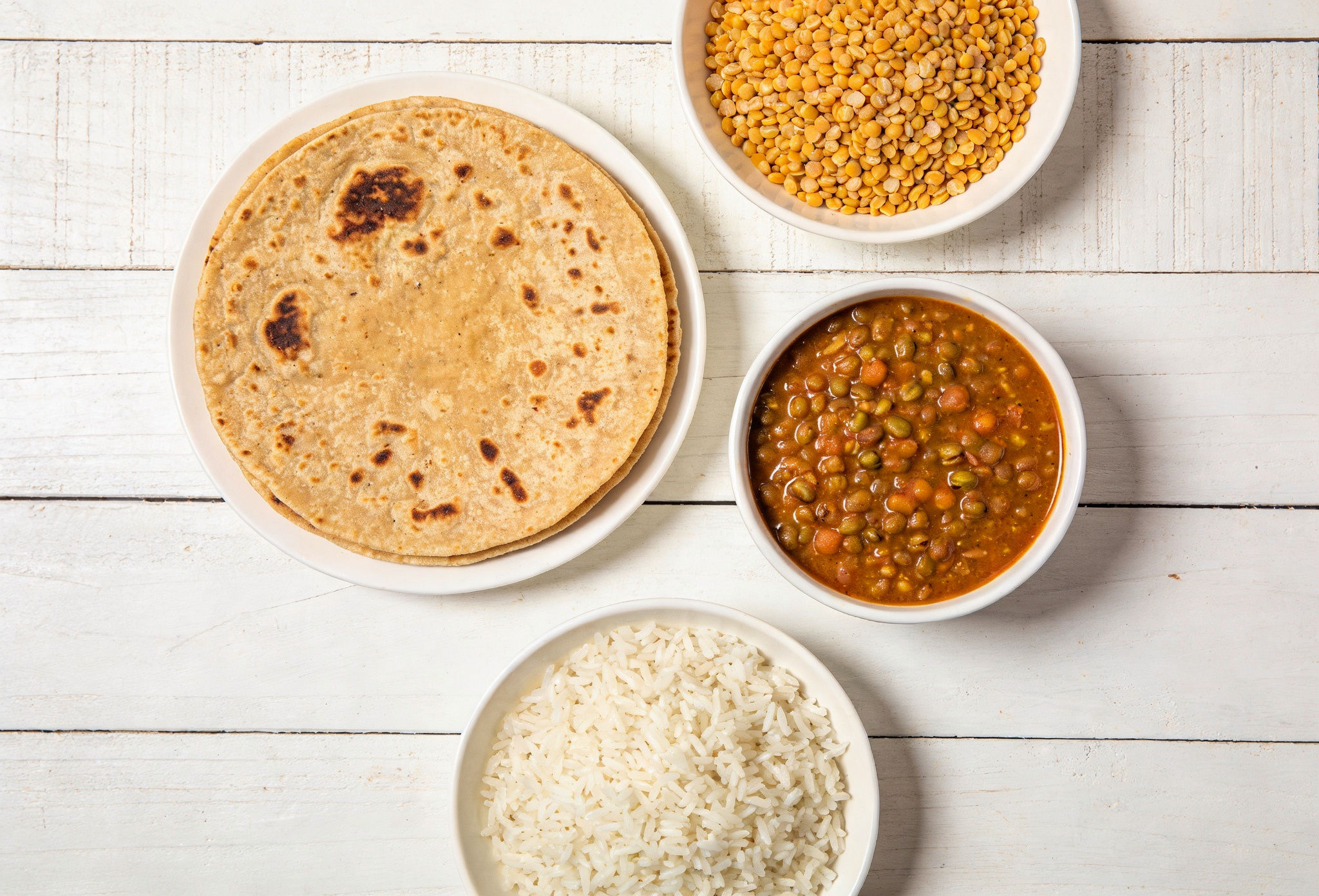 Indian foods modified for Low FODMAP diet: millet roti, rice, lactose-free curd, and small portions of dal for IBS relief.
