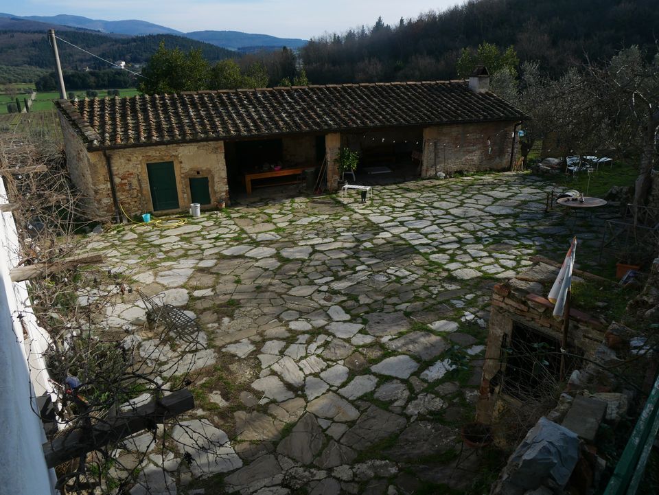 Il cortile in pietra di Casa Luce affacciato sulle colline