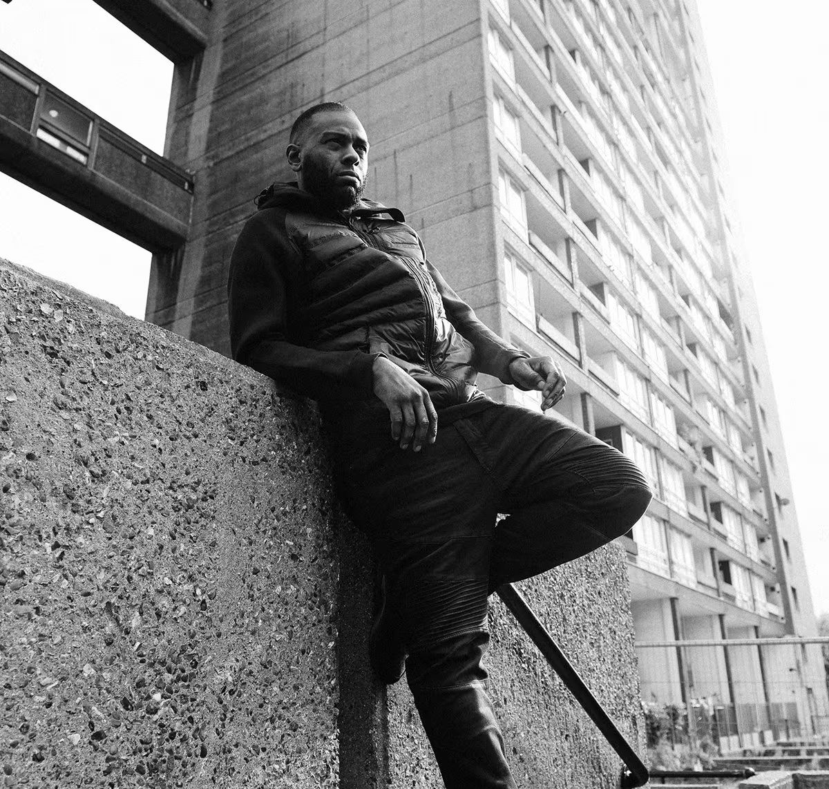 uma foto a preto e branco de um homem negro numa paisagem urbana