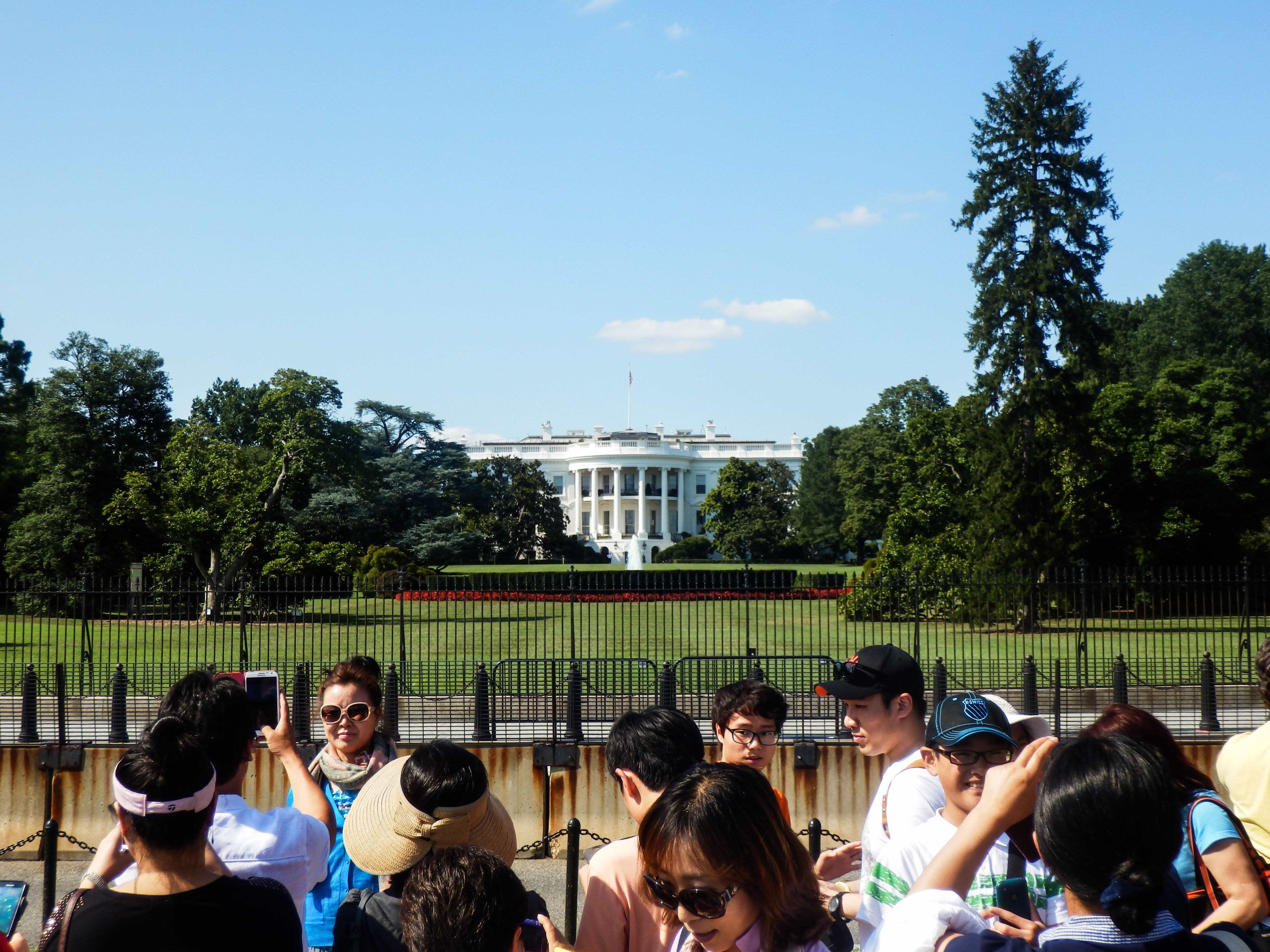 a group of East Asian people in front of the White House