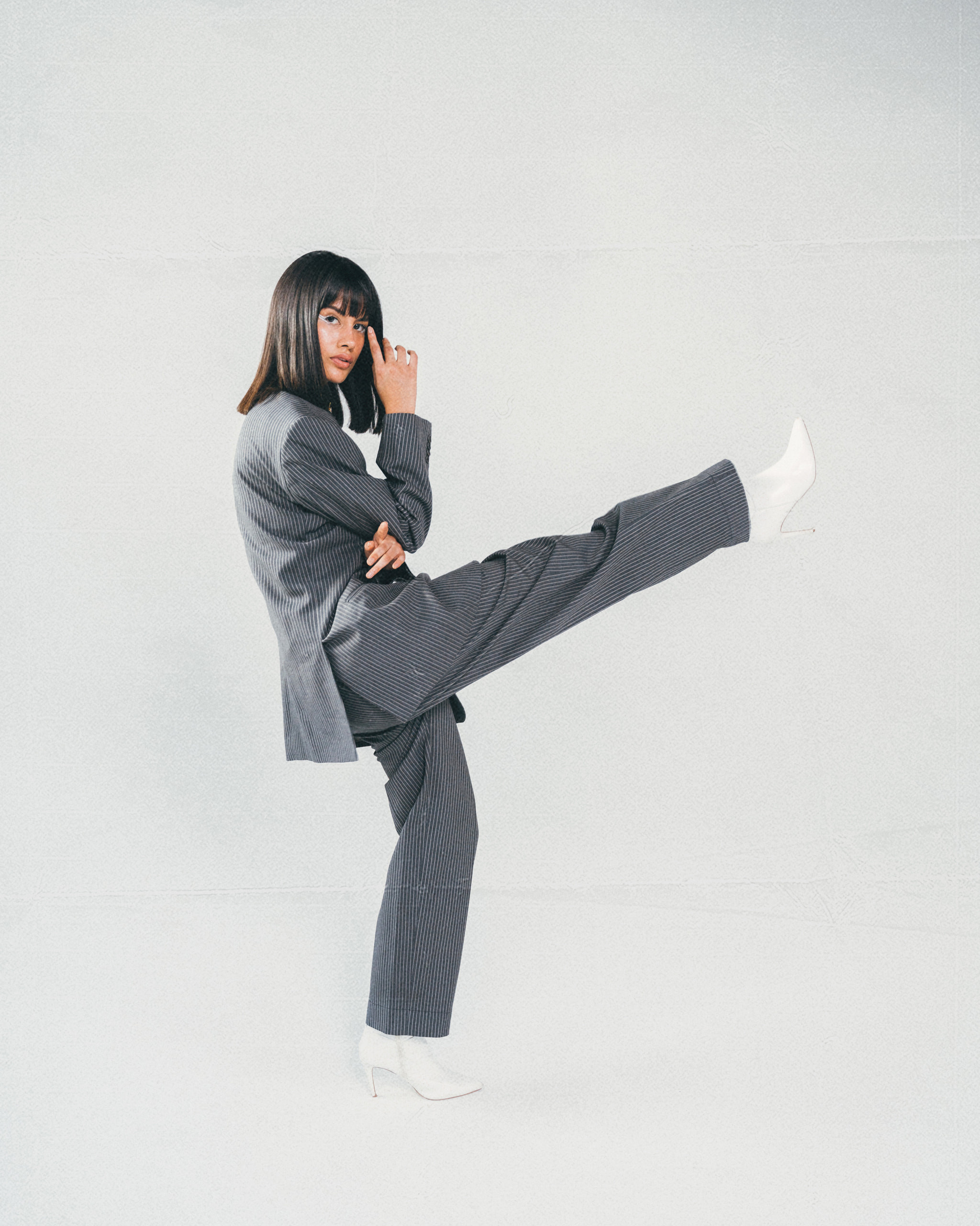Pierina en movimiento con traje gris y zapatillas blancas