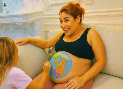 Niño pintando la barriga de su mamá embarazada