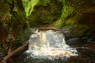 Devil’s Pulpit, Finnich Glen - a beautiful moss covered gorge in Scotland. A small waterfall