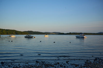 Loch Lomond - Tranquil sunset scene with boats peacefully sailing on serene water, embraced by fading light and complemented by a playful kite.