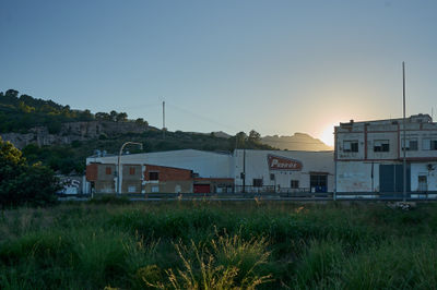 Favara, Valencia: A vibrant urban scene with a prominent building, surrounded by green grass. The building has numerous windows and a sign.