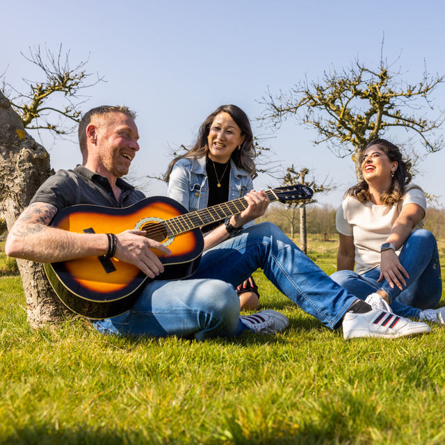 Drie personen met gitaar