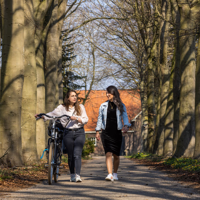 Twee vrouwen wandelen met fiets